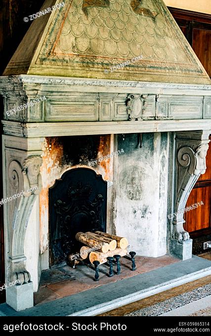 Old firebox in the house close-up. An ancient fireplace in the house with columns and bas-reliefs. High quality photo