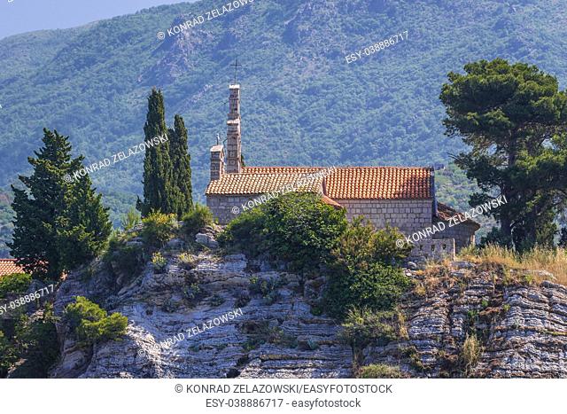 Church on Sveti Stefan islet and five star Aman Sveti Stefan hotel resort on the Adriatic coast of Montenegro