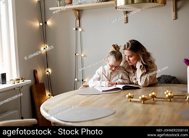 Mother helping daughter doing homework