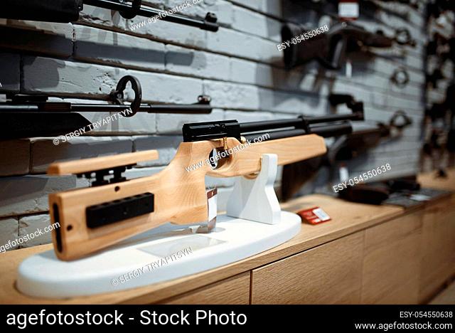 Pneumatic rifles on showcase in gun shop closeup, nobody. Euqipment for hunters on stand in weapon store, hunting and sport shooting hobby