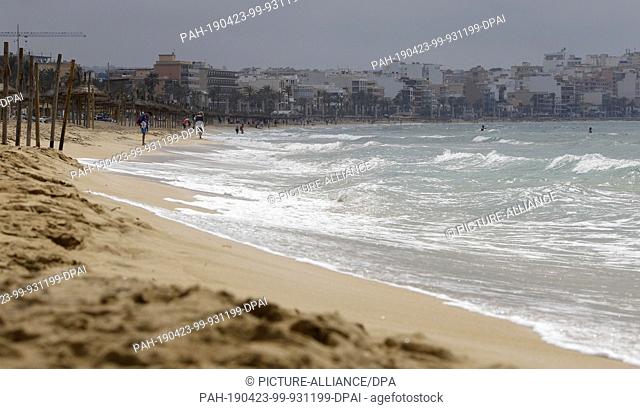 23 April 2019, Spain, Palma: Waves hit the beach of Arenal at the bay of Palma. In the background you can see buildings. The Mallorca Hotelier Association...