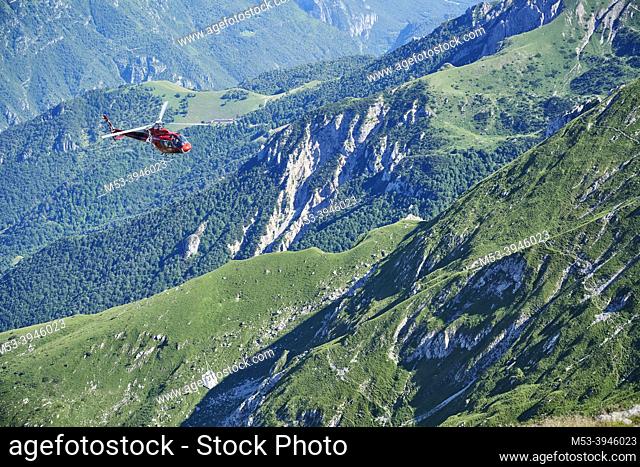 A Eurocopter AS350 B3 service helicopter carrying a food cargo to a mountain hut. Northern Grigna mountain. Province of Lecco. Lombardy. Italy