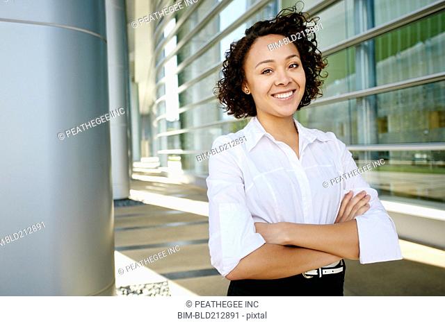 Mixed race businesswoman standing on city street