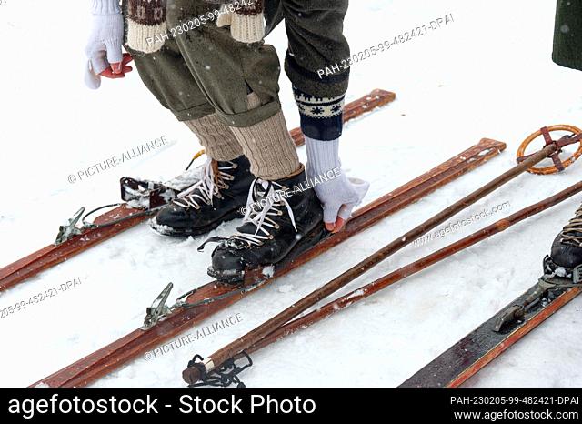 05 February 2023, North Rhine-Westphalia, Winterberg: A participant gets into an old-fashioned ski binding at the Nostalgia Ski Race in Winterberg-Neuastenberg