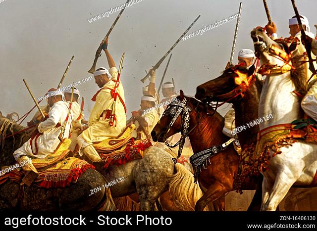 EL JADIDAH, CASABLANCA , MOROCCO - August 02, 2015 : Traditionally dressed Moroccan tribals and horsemen riding the horses and fire the rifles full of...