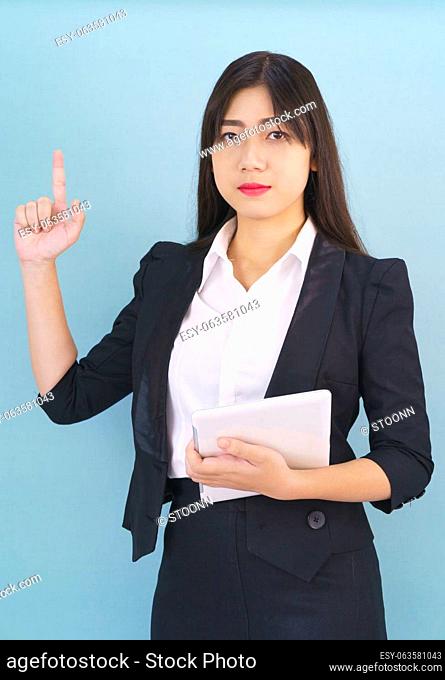 Young women standing in suit holding her digital tablet computor against blue background