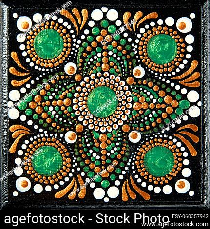 Mandala dot art painting on wood tiles. Beautiful mandala hand painted by colorful dots on black wood. National patterns with acrylic paints, handwork