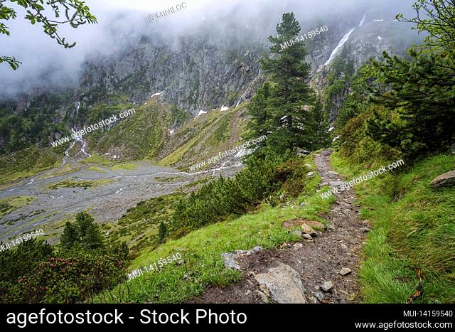summer view of alpine mountain valley with winding stream and glacial lake. sulzenau alm, stubai alps, austria