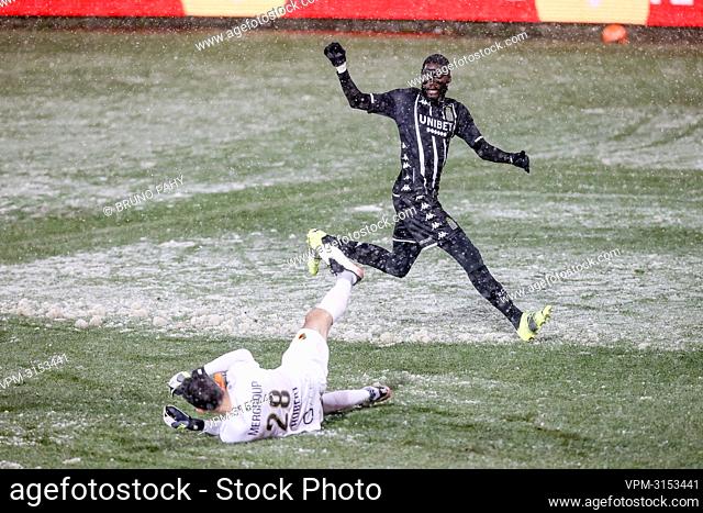 Oostende's goalkeeper Guillaume Hubert and Charleroi's Shamar Nicholson fight for the ball in the snow during a soccer match between Sporting Charleroi and KV...
