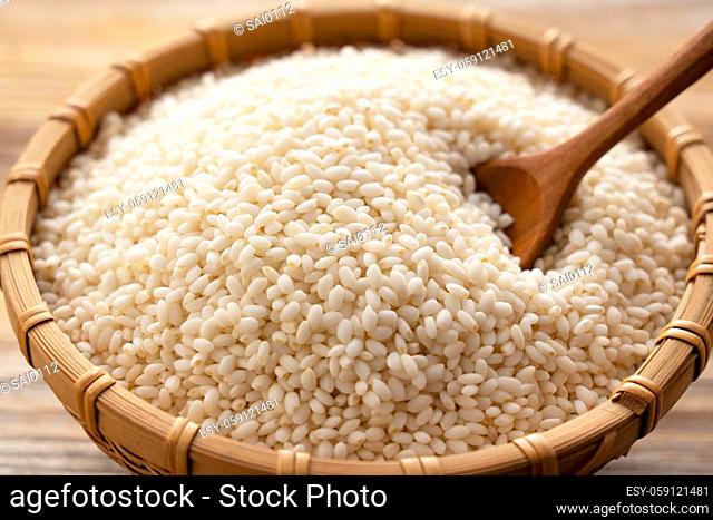 Glutinous rice in a bamboo colander set against a background of trees with copy space