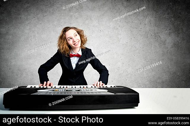 Funny crazy woman in suit and bow tie playing piano
