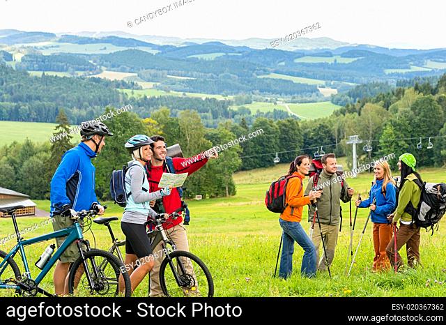 Hikers helping cyclists following track nature landscape