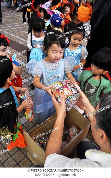Naha, Okinawa, Japan: children getting gifts during Halloween in Heiwa-dori shopping arcade, Makishi