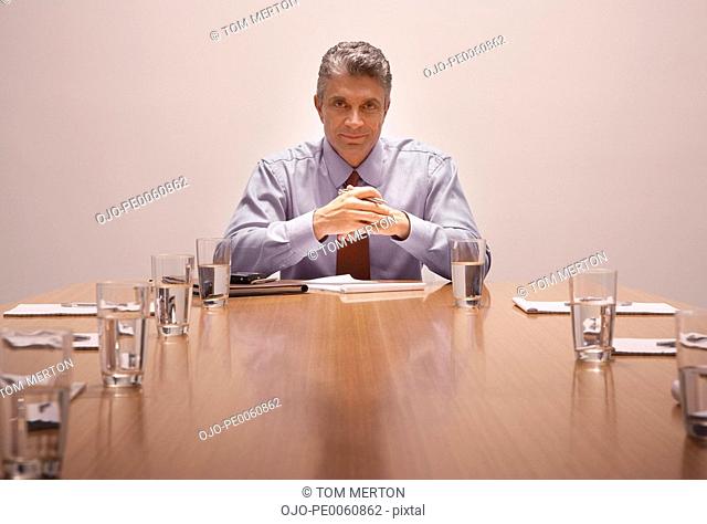 Businessman in boardroom looking at camera