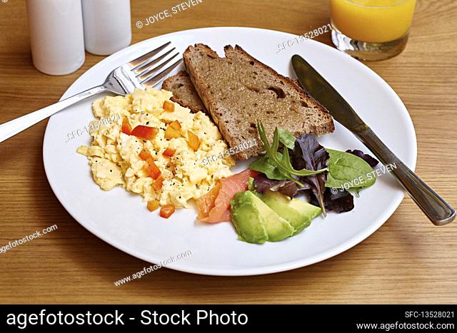 Scrambled eggs, smoked salmon, avocado, brown toast and salad