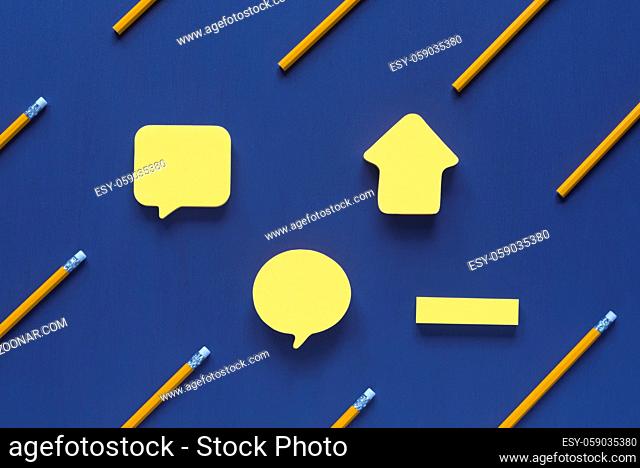 Yellow sticky notes in different sizes and shapes, with place for text, placed on a blue wooden background, surrounded by yellow wooden pencils