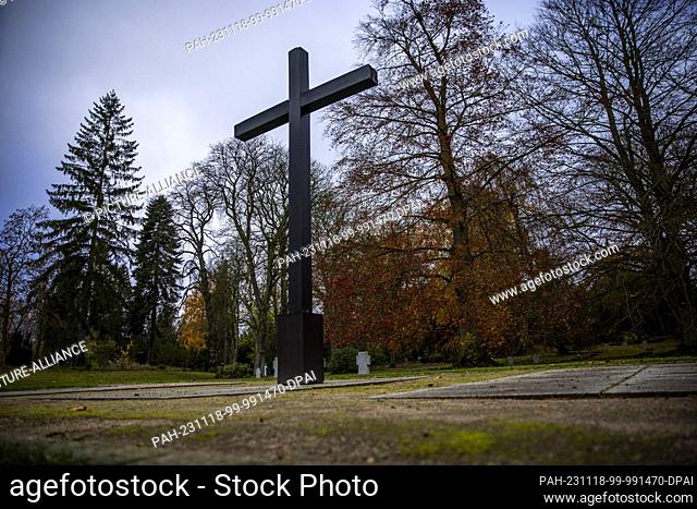 PRODUCTION - 17 November 2023, Mecklenburg-Western Pomerania, Schwerin: A large wooden cross stands at the war graves memorial in the old cemetery