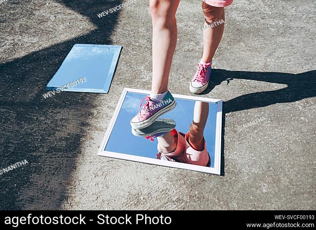 Woman stepping on mirrors wearing canvas shoes
