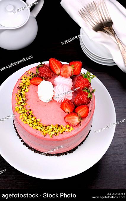 Chocolate strawberry cake decorated with berries, meringue and pistachios