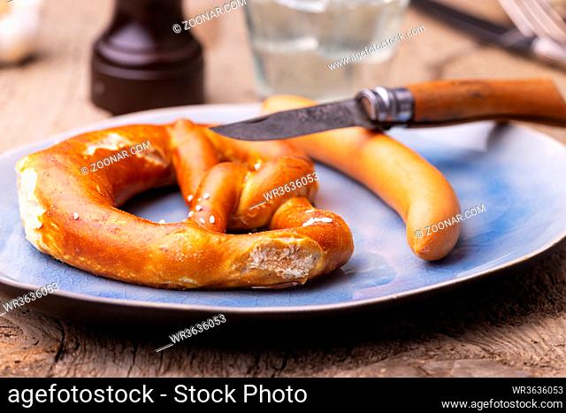 pretzel with frankfurt sausage on a plate