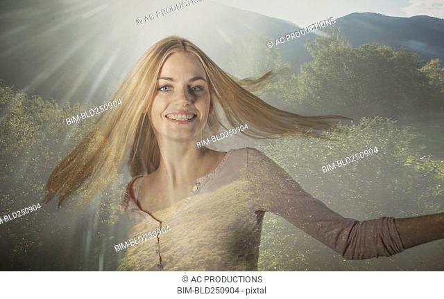 Double exposure of Caucasian woman spinning in forest trees