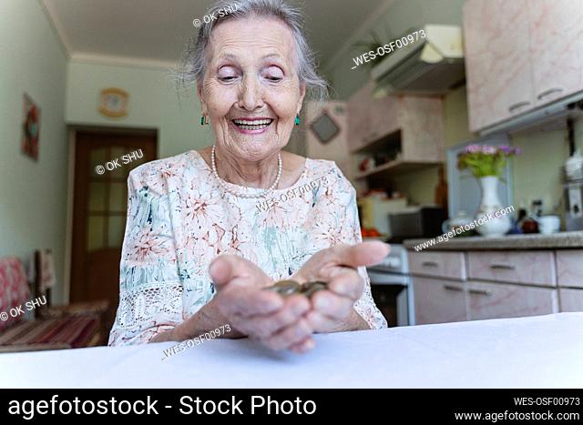 Happy senior woman looking at coins