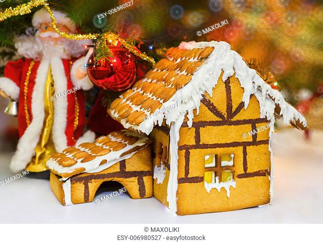Christmas gingerbread house decoration on background of defocused christmas tree. Hand decorated