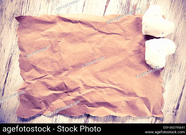 Brown package paper and love hearts on wooden background