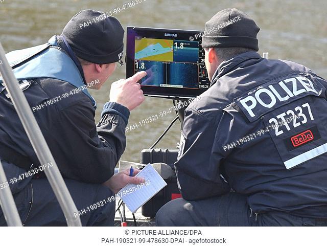 20 March 2019, Brandenburg, Wolzig: Police officers look at an echo sounder on a boat in search of the missing Rebecca at the Storkower Canal near Wolziger See...