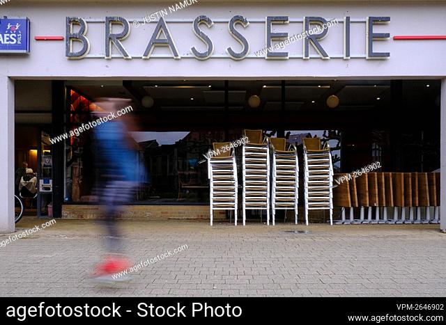 Illustration picture shows people passing by a closed bar in Louvain-La-Neuve on Wednesday 17 February 2021...BELGA PHOTO JUSTIN NAMUR