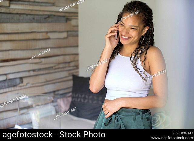 Happy young woman talking on smart phone