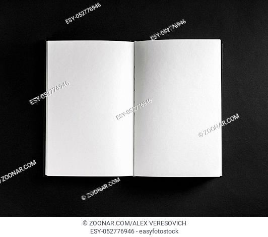 Book, notebook or booklet with blank pages on black paper background. Top view. Flat lay