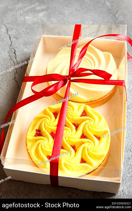 Delicious mini tarts yellow and white with nuts and custard in the gift box. Assortment of delicious and colorful dessert, lemon curd tart