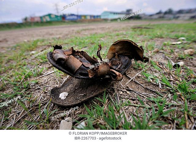 Old leather sandal lying on a football field, Lomas de Santa Faz slum, Guatemala City, Guatemala, Central America