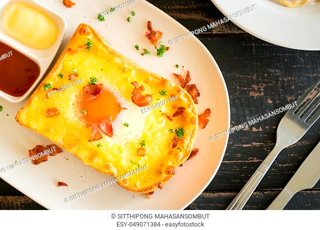 Egg Yolk Bacon Ham Cheese Toast and Coriander. Breakfast egg yolk bacon ham cheese with bread toast with coriander on top for food and drink category