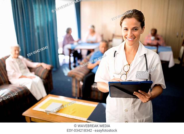 Smiling female doctor standing with file