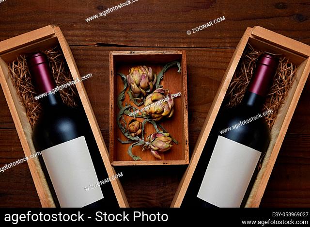 Wien Still Life: Two wood wine boxes with red wine bottles with a small wooden box with dried artichokes