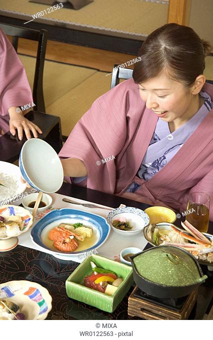 Two young women eating dinner in Japanese style inn