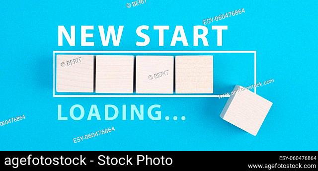 Words new start with a loading bar, hand puts last wooden cube on the blue background
