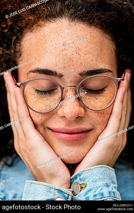 Beautiful young woman wearing eyeglasses with eyes closed