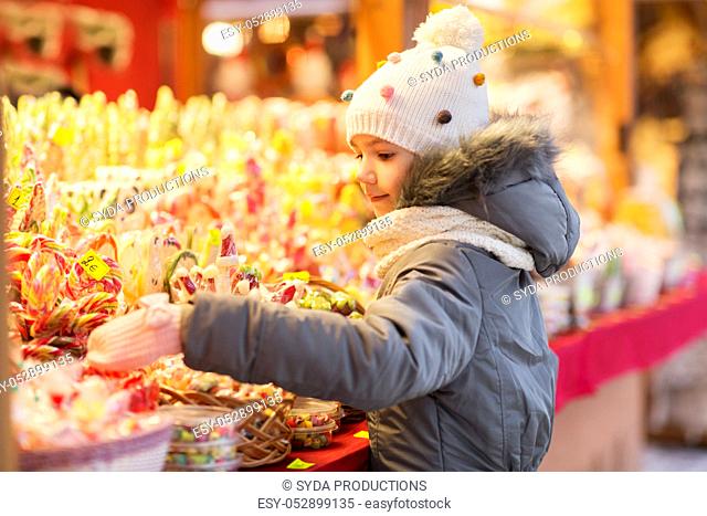 little girl choosing sweets at christmas market