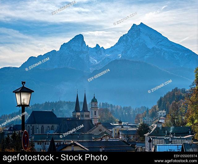 Autumn hazy day famous Bavarian prealps Berchtesgaden town and mount Watzmann silhouette in contra light, Germany