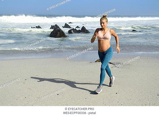 Pregnant woman jogging on the beach