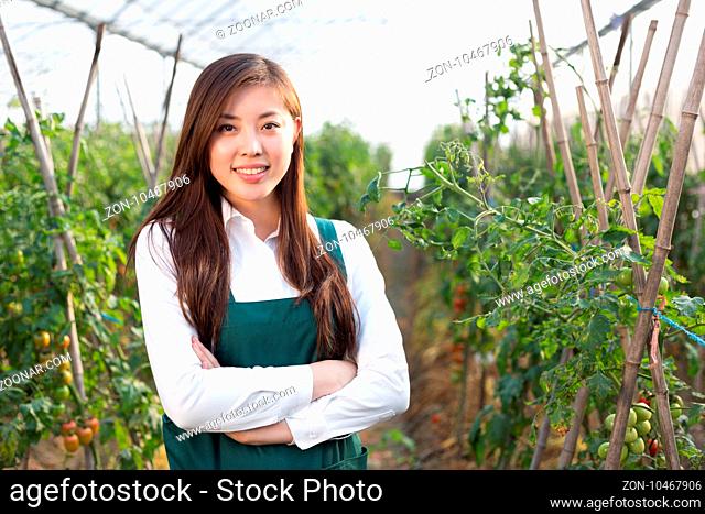 young beautiful asian woman works in green field