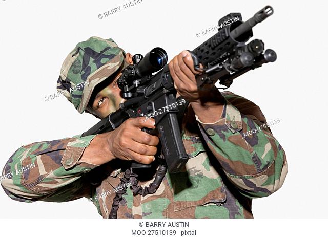 US Marine Corps soldier aiming M4 assault rifle against gray background