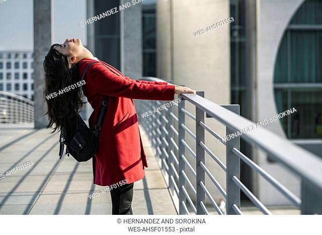Modern businesswoman getting relaxed standing on a bridge, Berlin, Germany