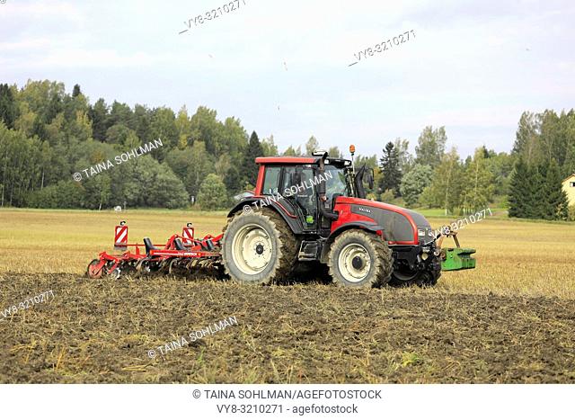 Salo, Finland - September 21, 2018: Farmer cultivates harvested stubble field with Valtra tractor and Horsch Terrano 3 FX cultivator in autumn