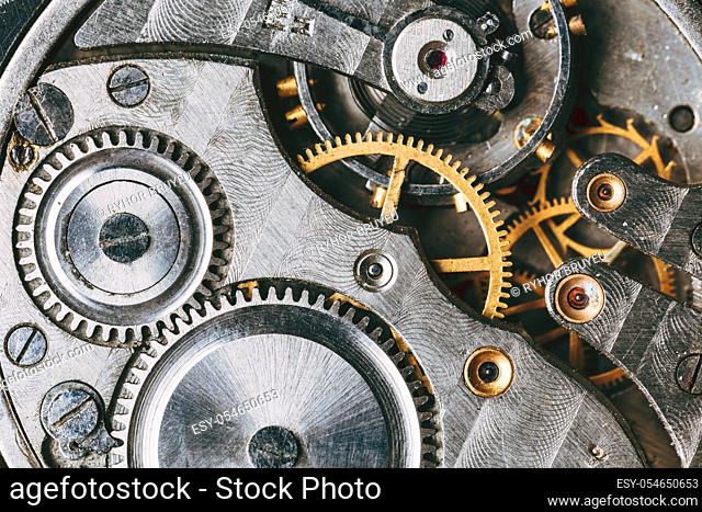 Close-Up Of Old Clock Watch Mechanism. Retro Clockwork Watch With Gray And Golden Gearwheels Gears. Vintage Movement Mechanics