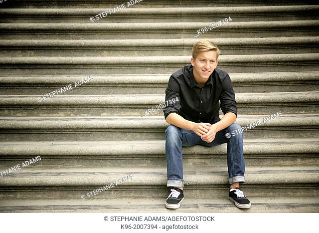 Young man sitting on stone steps