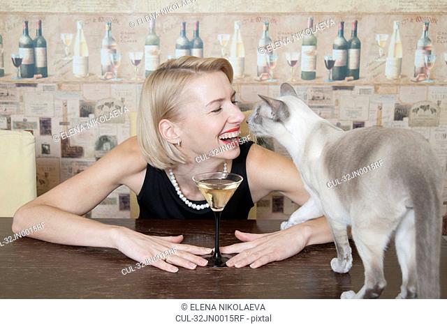 Woman drinking martini with cat